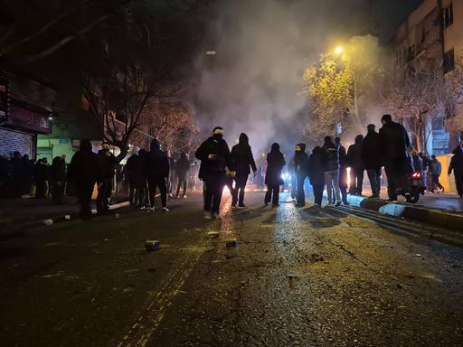 Auf diesem Bild vom 9.1. aus Teheran sind zahlreiche Protestierende zu erkennen. Es ist Nacht, auf der Straße spiegelt sich das Licht. Die Personen sind vermummt. Auf diesem Bild vom 9.1. aus Teheran sind zahlreiche Protestierende zu erkennen. Es ist Nacht, auf der Straße spiegelt sich das Licht. Die Personen sind vermummt.