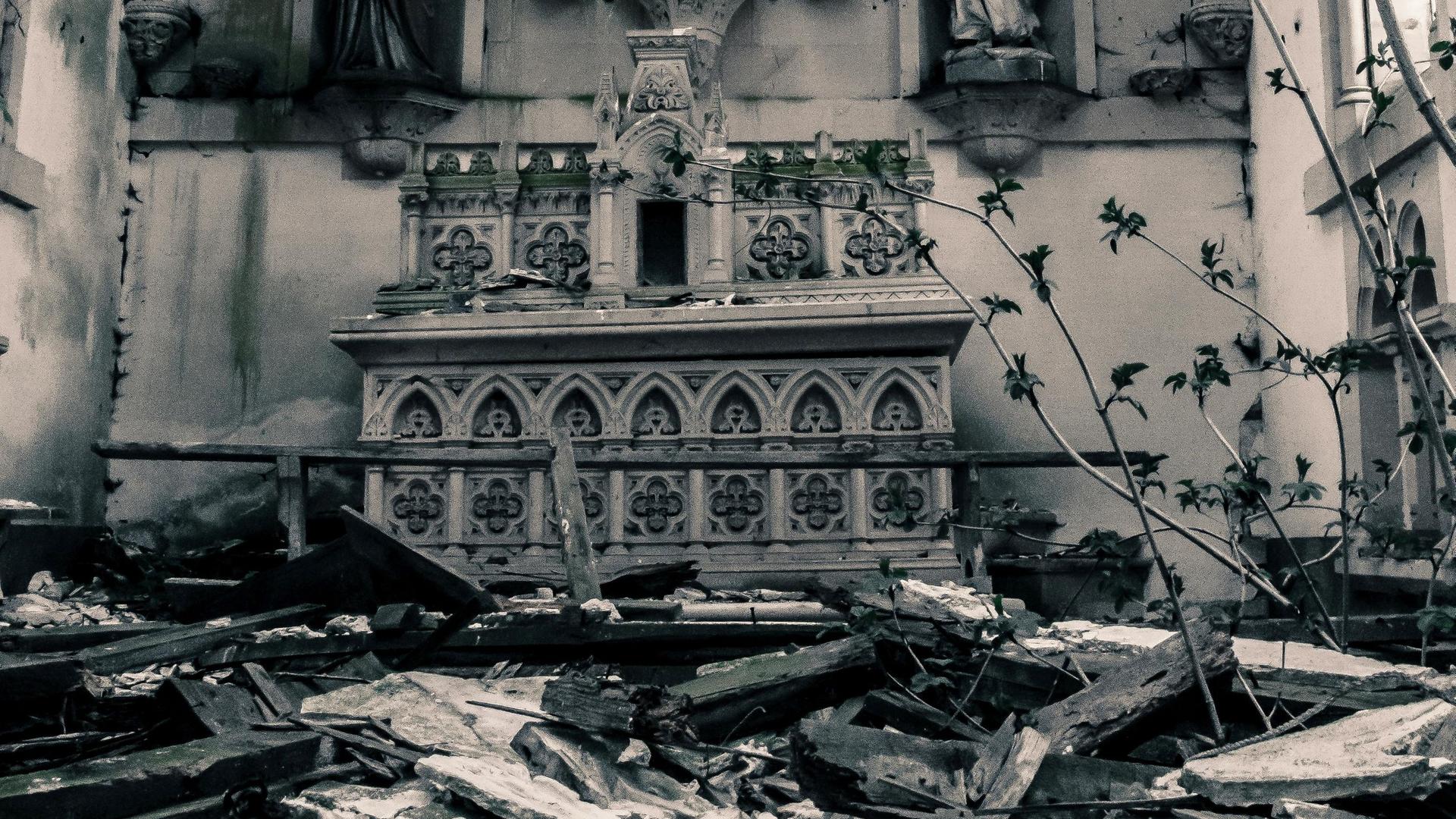 Blick in einen Krichenraum mit Altar, in den das Dach eingestürzt ist und damit den Raum unpassierbar macht.