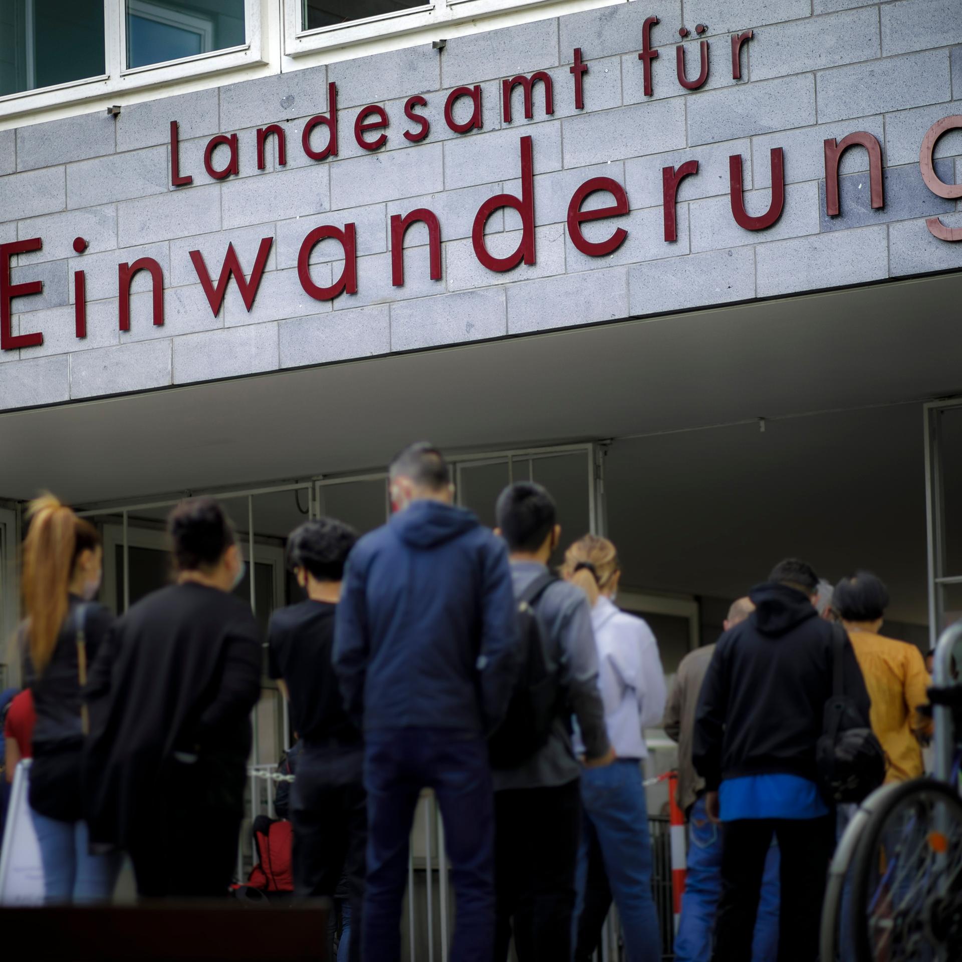 Wartende Menschen stehen vor dem Landesamt fuer Einwanderung in Berlin