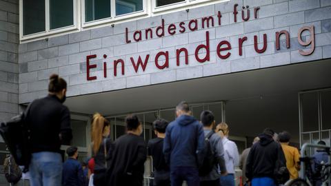 Wartende Menschen stehen vor dem Landesamt fuer Einwanderung in Berlin