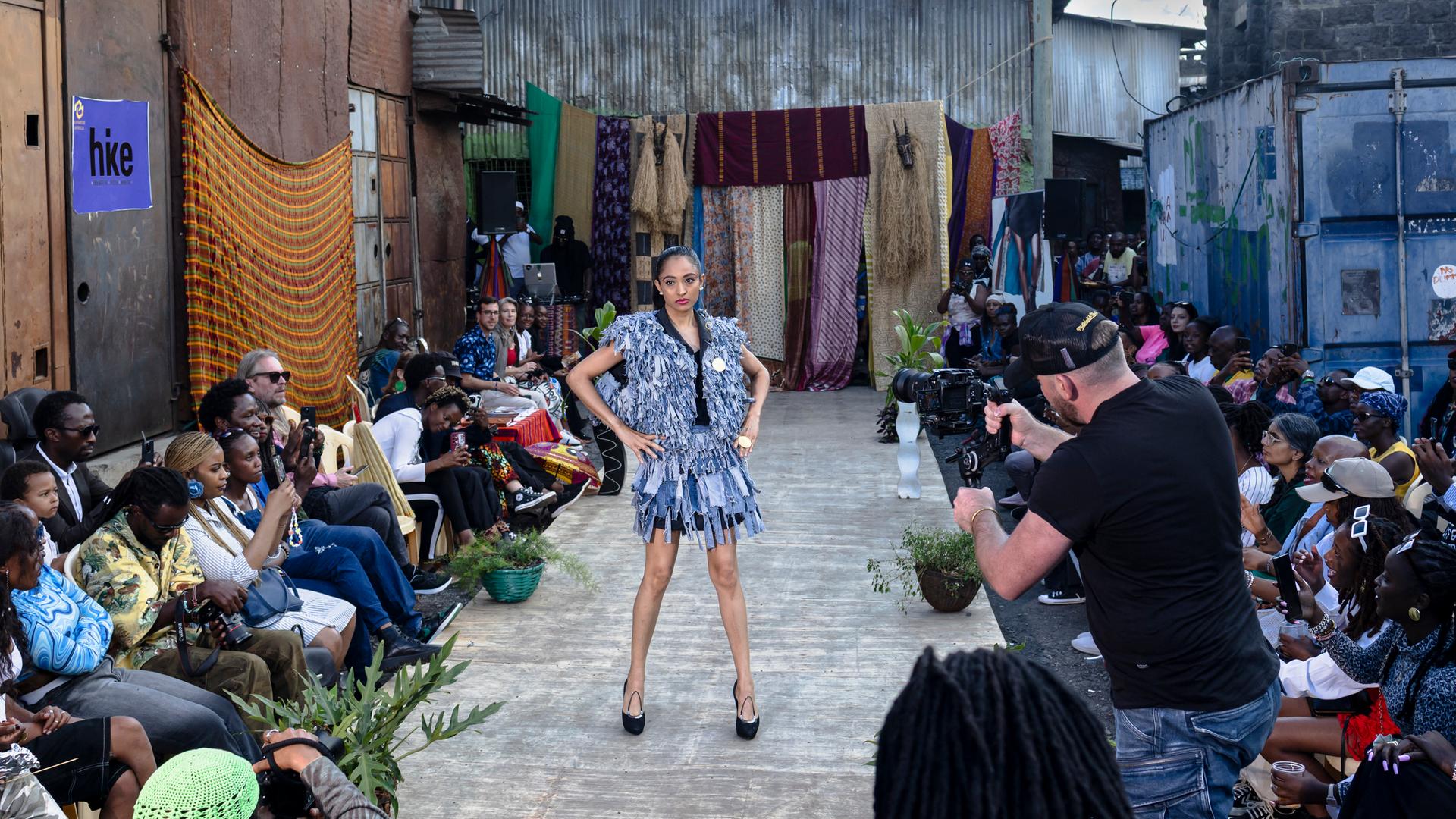 Bei der Modenschau „Wasteland Gikomba Fashion” in Nairobi laufen Models in Outfits, die von lokalen Modedesignern aus Secondhand-Kleidermärkten entworfen wurden, über den Laufsteg. Bei der Modenschau „Wasteland Gikomba Fashion” in Nairobi laufen Models in Outfits, die von lokalen Modedesignern aus Secondhand-Kleidermärkten entworfen wurden, über den Laufsteg.