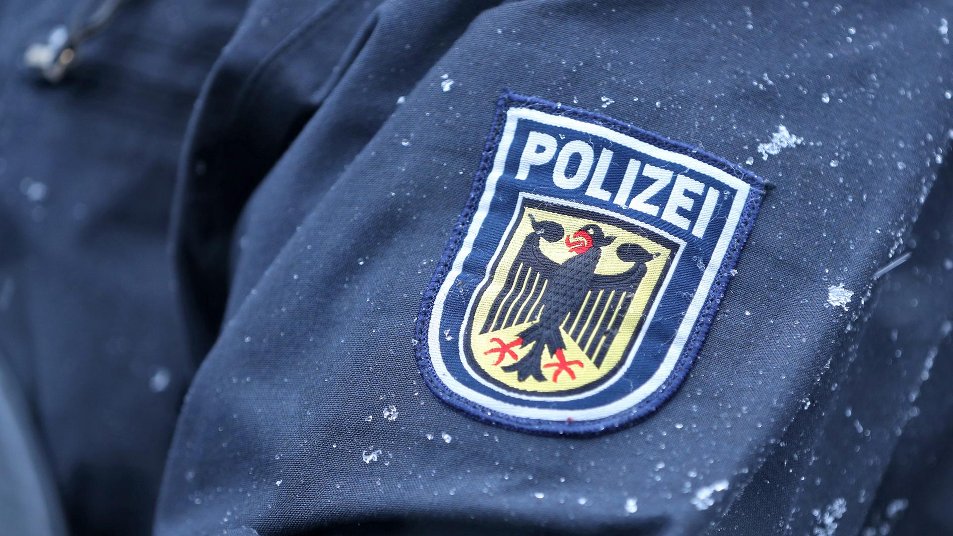Auf einem Aufnäher auf einer Uniform prangt das Logo der Bundespolizei mit Schriftzug Polizei. Dies ist in Großaufnahme zu sehen.