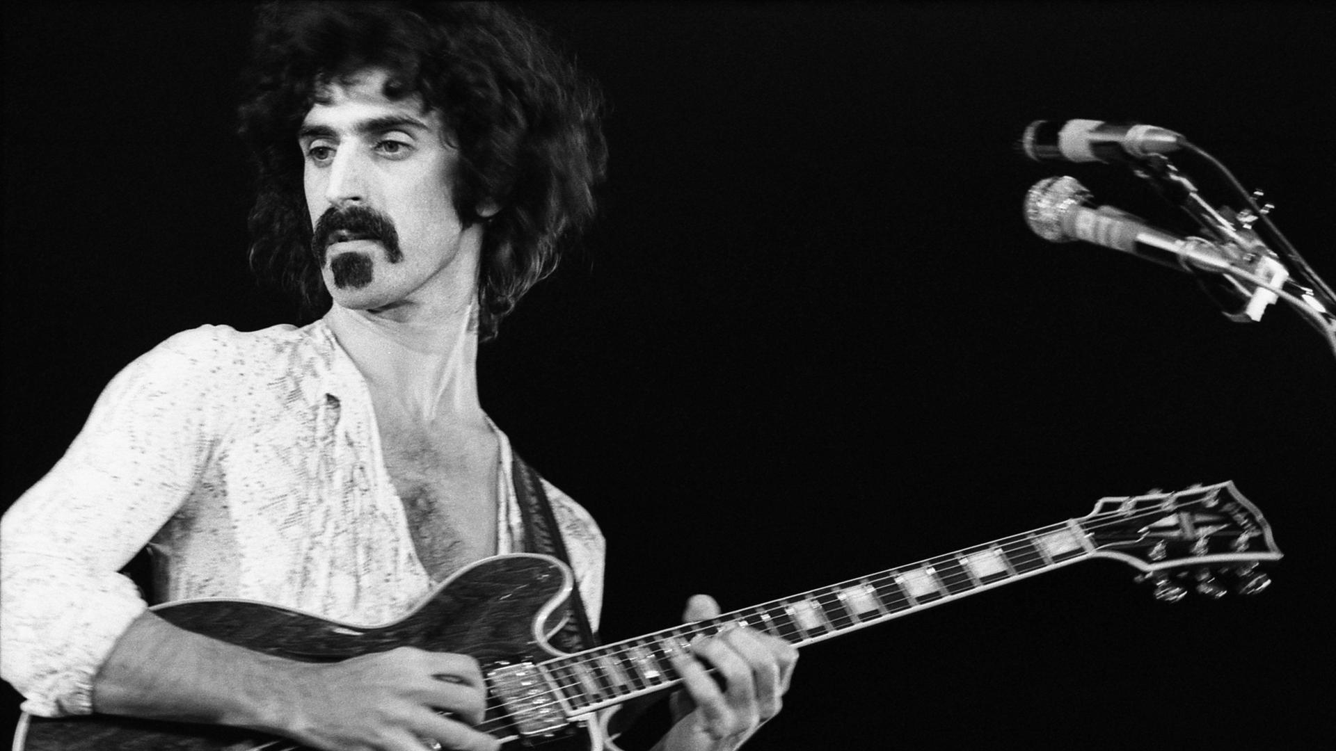 Frank Zappa spielt Gitarre auf einer Bühne in Paris im Jahr 1970.