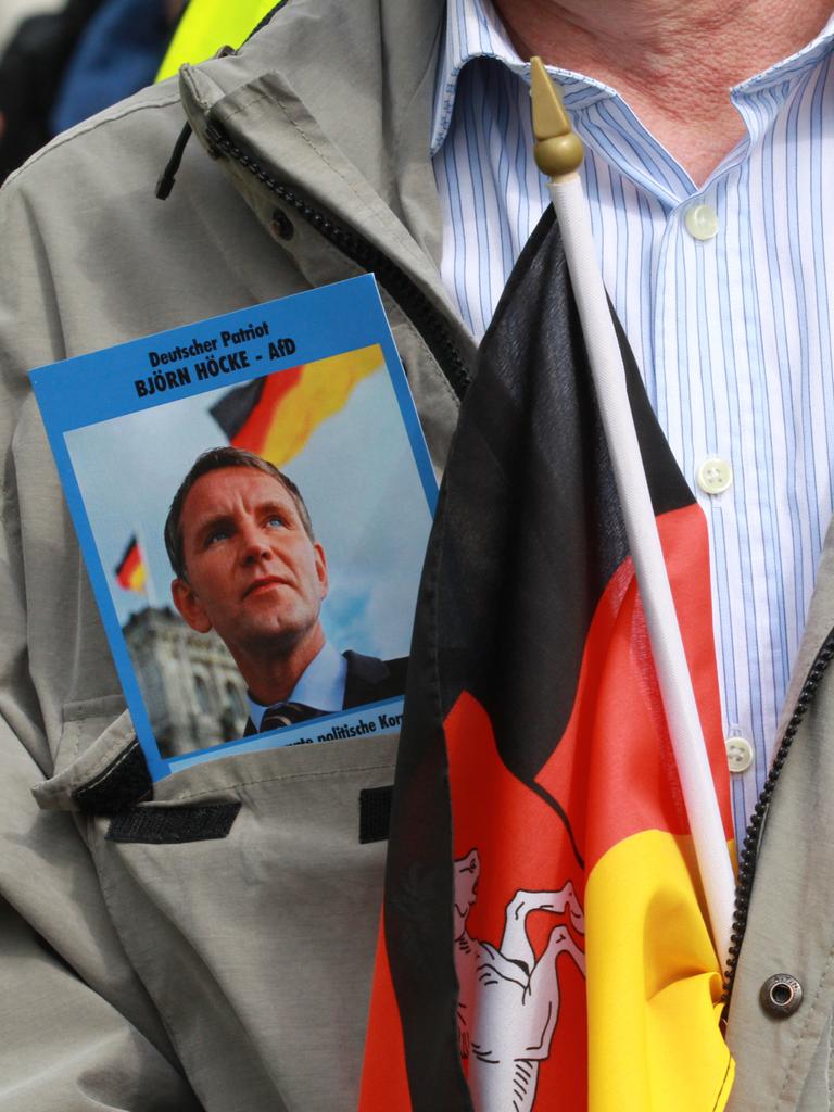 Ein Anhänger der AfD demonstriert mit zwei Fotos von Björn Höcke, Fraktionsvorsitzender der AfD im Landtag und einer Deutschlandfahne in der Innenstadt.
