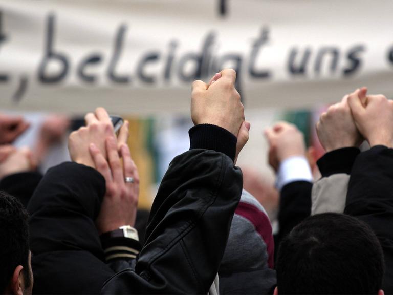 Muslime protestieren mit Transparenten in Berlin gegen die Veröffentlichung von Karikaturen des Propheten Mohammed.