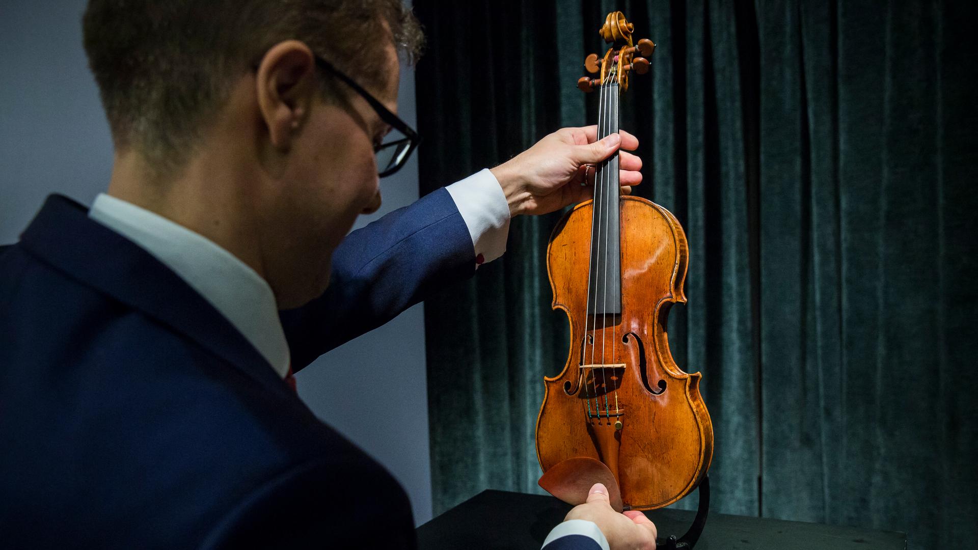 Ein Mitarbeiter von Sotheby's in Hong Kong hält eine wertvolle Stradivari Violine von 1684 in den Händen. Sie soll zwischen 1.55 - 2.45 Millionen Dollar einbringen. 21. Februar 2017.