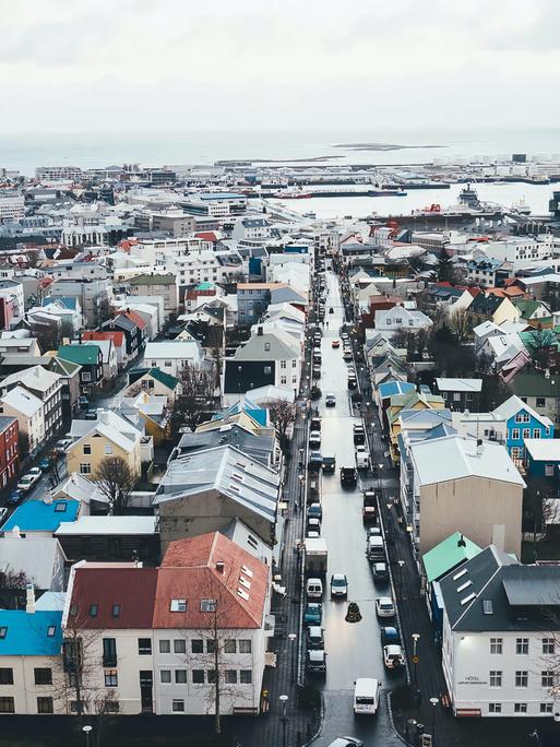 Vogelperspektive von Reykjavik mit zahlreichen Gebäuden und der Küstenlinie im Hintergrund.