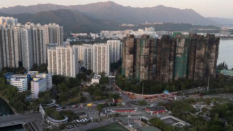 Das Bild zeigt mehrere verbrannte Hochhäuser mit verußten Fassaden.