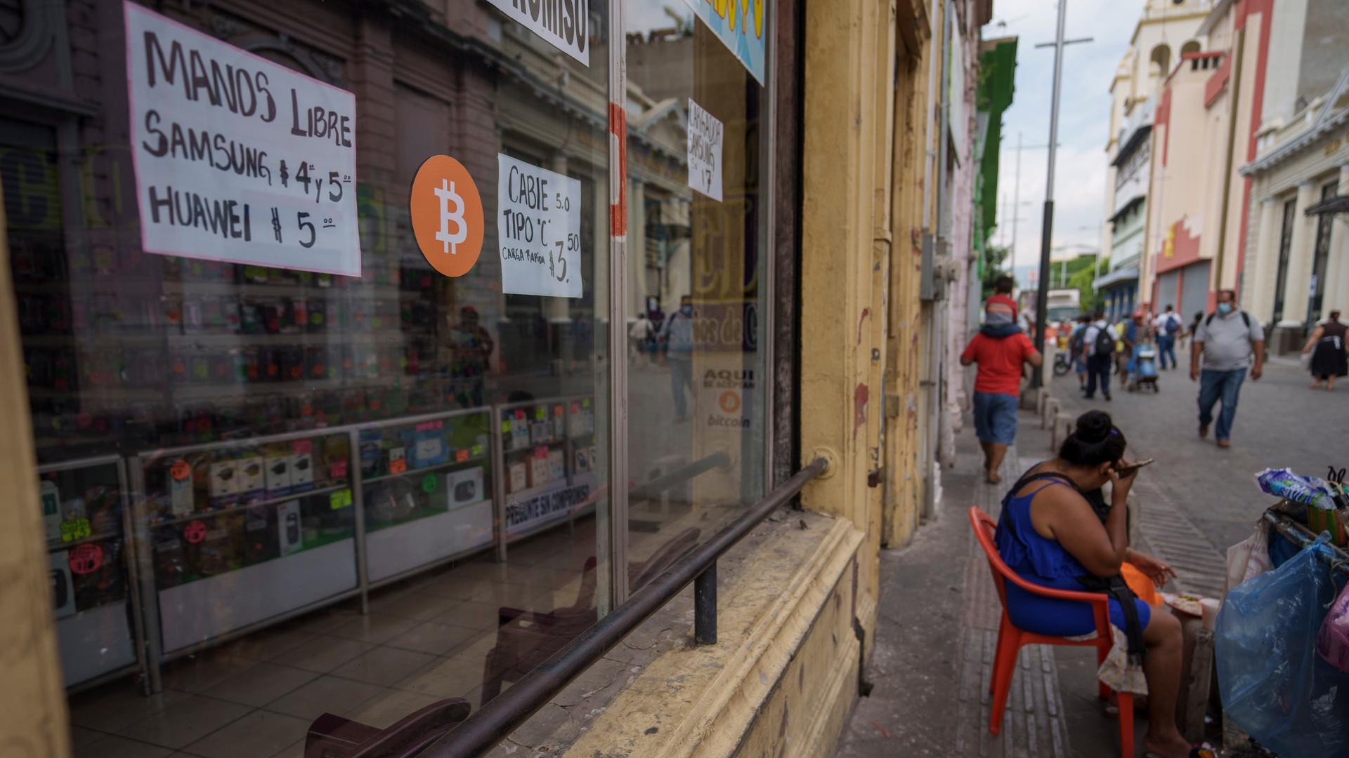 Ein Zeichen für die Zahlungsmöglichkeit mit Bitcoin ist an der Fensterscheibe eines kleinen Straßengeschäfts angebracht. 