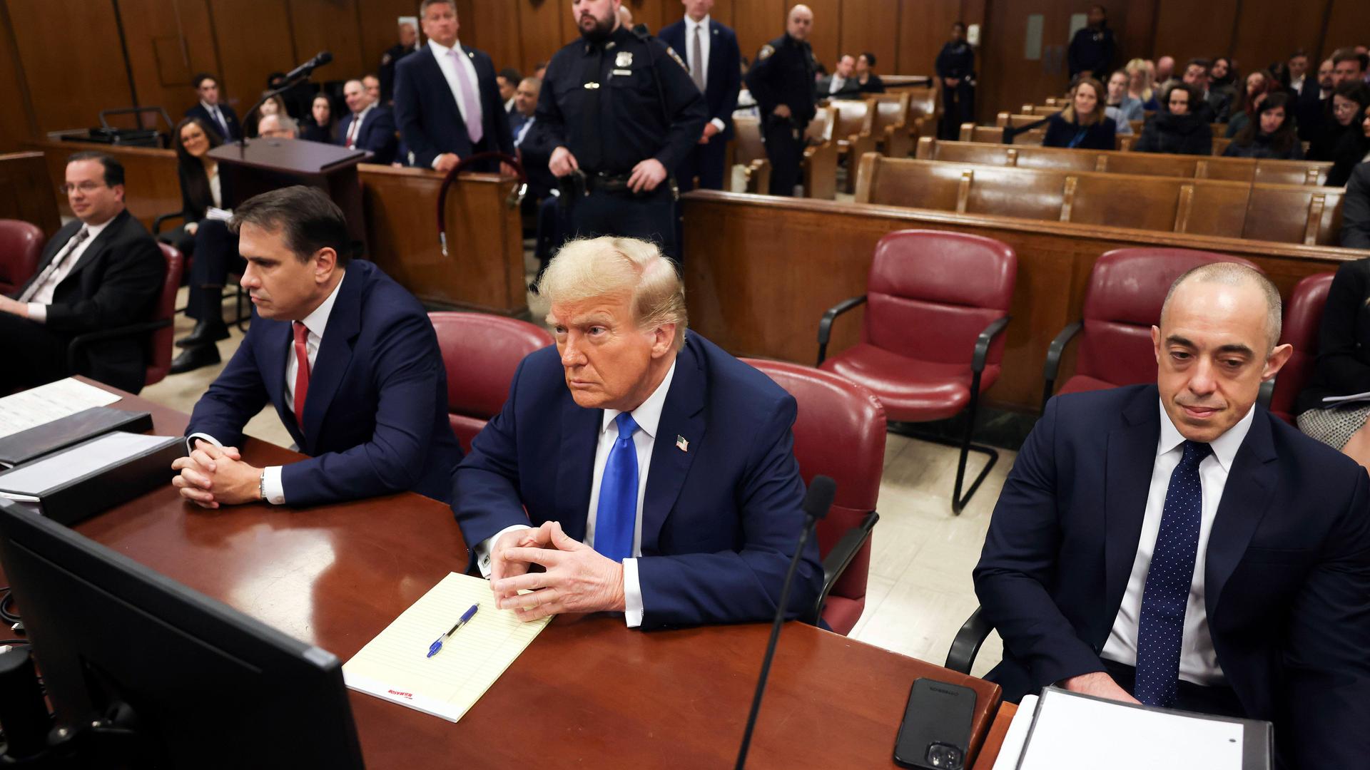 Der ehemalige Präsident und republikanische Präsidentschaftskandidat Donald Trump sitzt vor der Eröffnung der Verhandlung im Gerichtssaal.