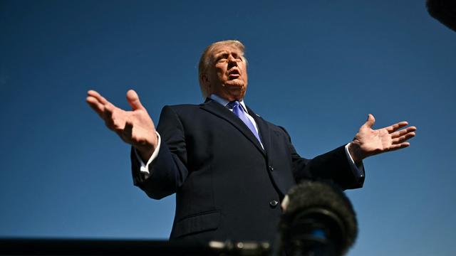 Starke Untersicht auf Donald Trump, der gestikulierend in ein Mikrofon spricht.