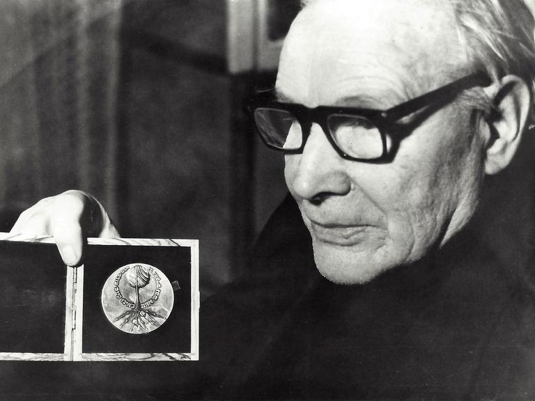 Der lettische Widerstandskämpfer Jānis Lipke ist auf einer Schwarzweiß-Fotografie aus dem Jahr 1977 zu sehen, er hält eine Auszeichnung in Form einer Medaille in der Hand.