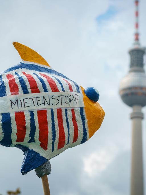 Bei einer Demonstration in Berlin sind ein Fisch mit der Aufschrift "Mietenstopp" und im Hintergrund der Berliner Fernsehturm zu sehen.