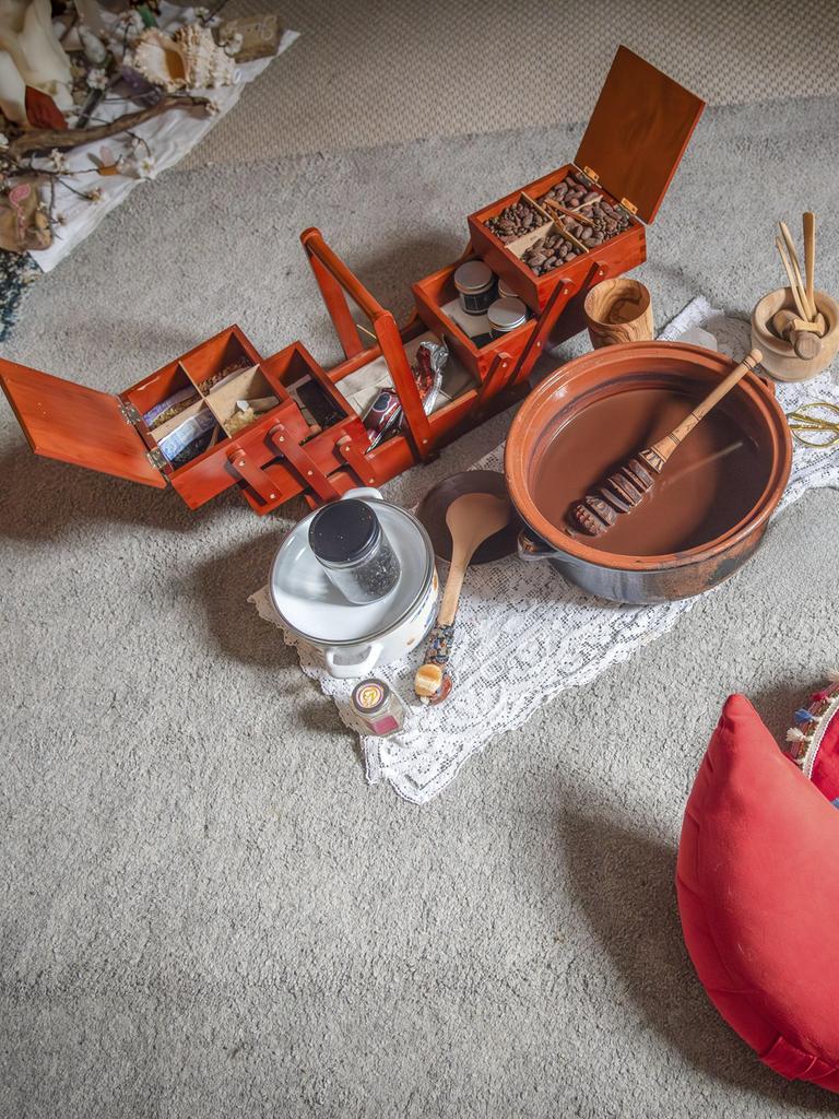 Meditationsecke mit roten Sitzkissen und einem Set aus Holzboxen, Schalen und Utensilien auf einem Teppich Meditationsecke mit roten Sitzkissen und einem Set aus Holzboxen, Schalen und Utensilien auf einem Teppich