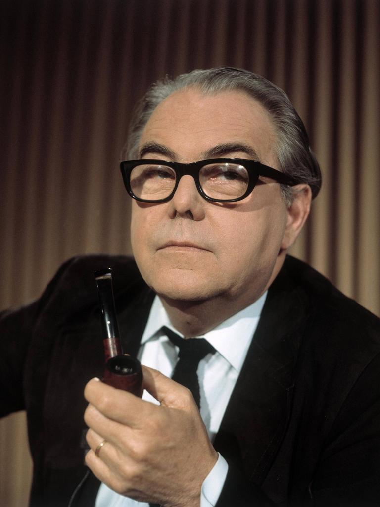 Der Schweizer Autor Max Frisch hält eine Pfeife in der Hand und schaut in die Kamera