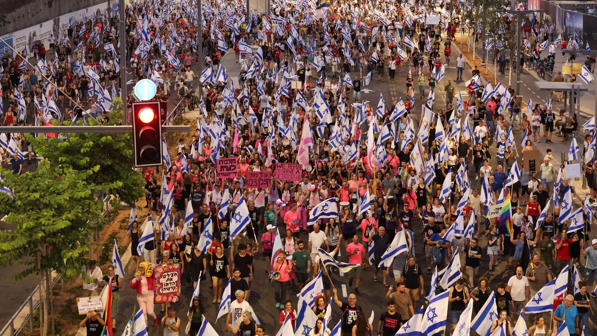 Tauende Menschen schwenken israelische Flaggen auf einer Straße in Tel Aviv