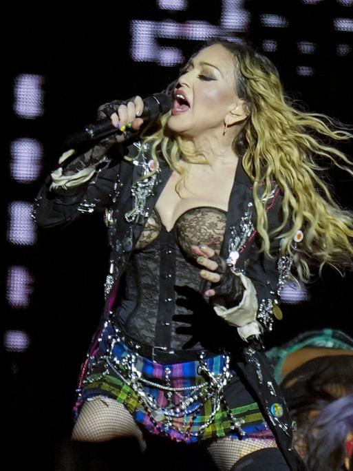 Die Sängerin Madonna tritt in der letzten Show ihrer "The Celebration Tour" am Strand der Copacabana auf. Sie singt in ein Mikrofon. 