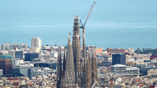 Eine große Kirche steht zwischen sehr vielen kleineren Häusern. Neben ihr steht ein großer Kran.