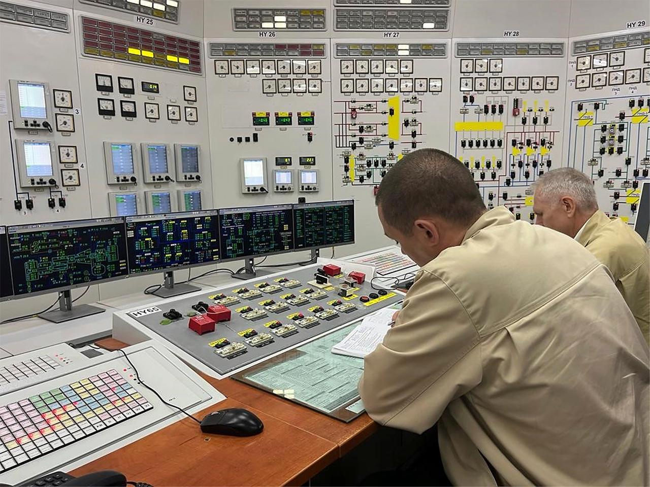Ukrainische Arbeiter an ihren Arbeitsplätzen im Kontrollraum des Kernkraftwerks Saporischschja.