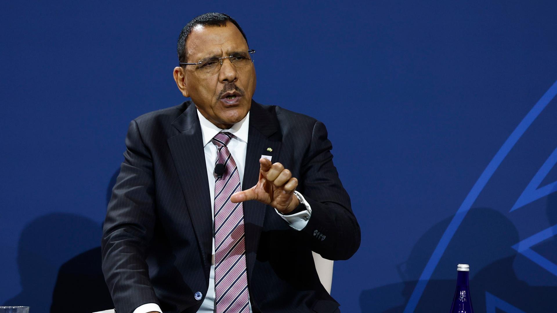 Nigers Präsident Mohamed Bazoum trägt einen Anzug und gestikuliert. Nigers Präsident Mohamed Bazoum trägt einen Anzug und gestikuliert.