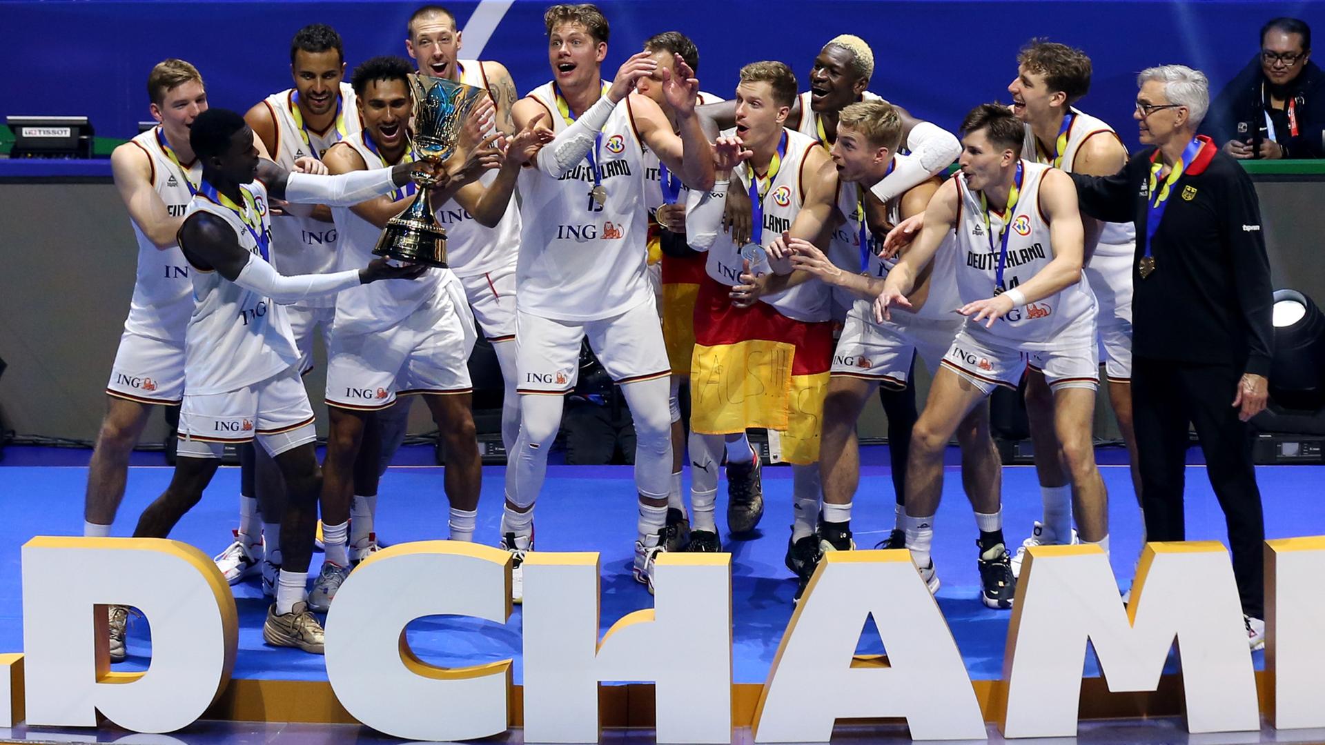 Die deutsche Basketball-Nationalmannschaft feiert bei der Siegerehrung der WM 2023 ihren ersten Weltmeistertitel.