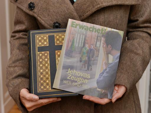 Ein Zeuge Jehovas mit Bibel und Broschüre "Erwachet" in der Hand.