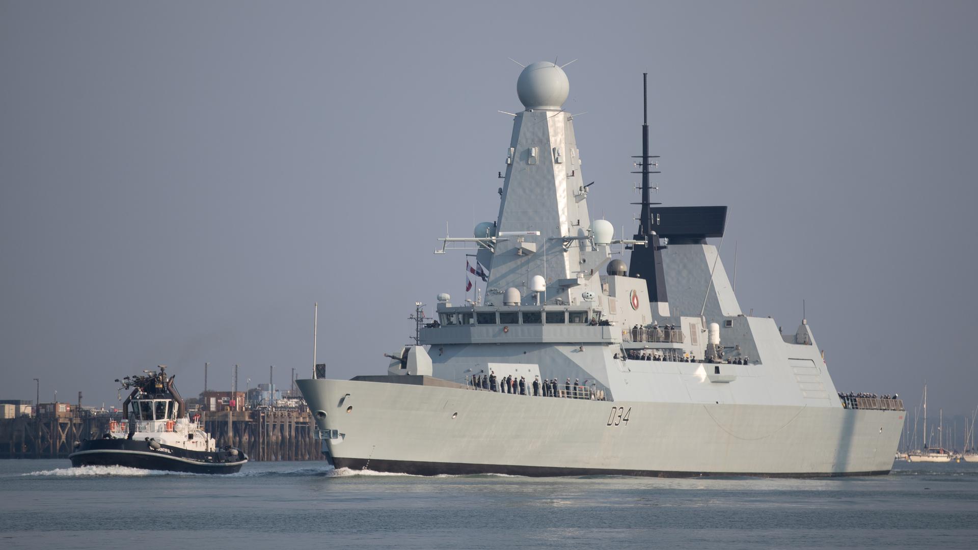 Der Zerstörer "HMS Diamond" der britischen Royal Navy fährt hinter einem kleineren Lotsenrboot her