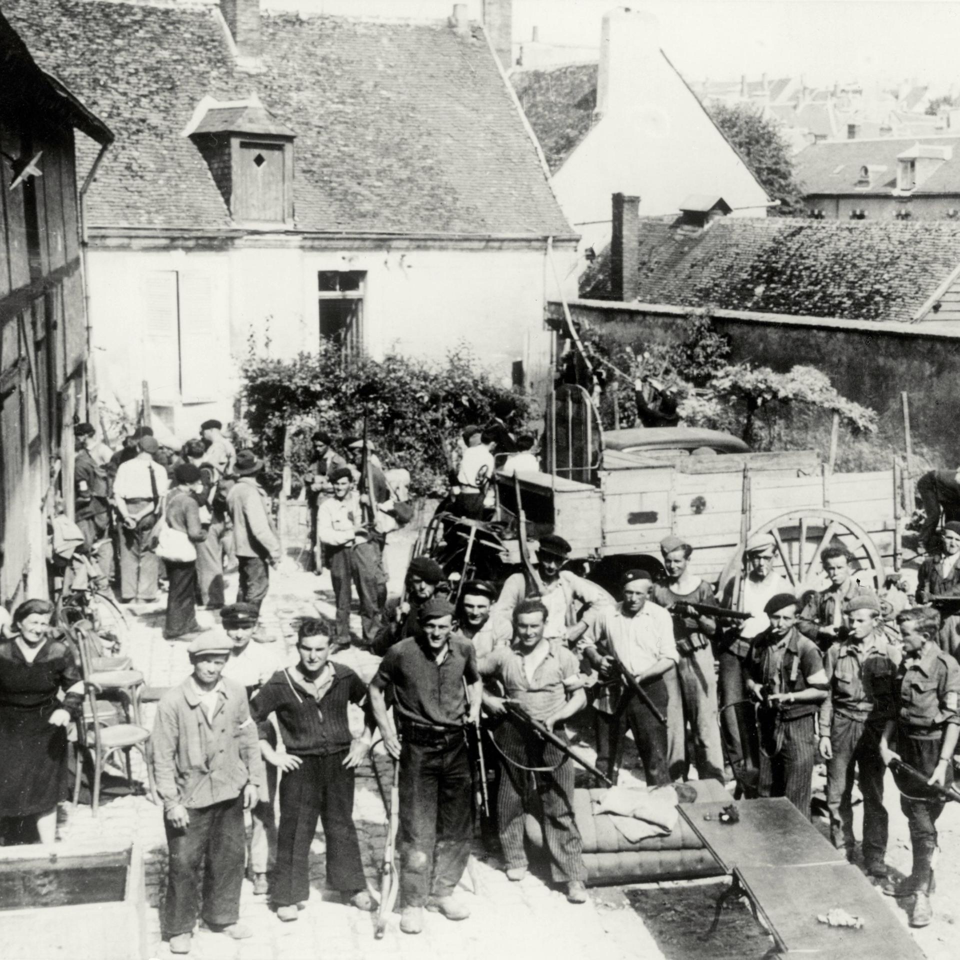 Nach der alliierten Invasion in der Normandie im Sommer 1944 wartet eine Gruppe von Partisanen mit Gewehren auf einem Gehöft (bei Chateaudun) auf den Einsatzbefehl gegen deutsche Stellungen.
