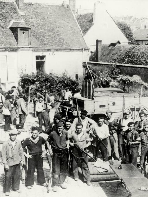 Nach der alliierten Invasion in der Normandie im Sommer 1944 wartet eine Gruppe von Partisanen mit Gewehren auf einem Gehöft (bei Chateaudun) auf den Einsatzbefehl gegen deutsche Stellungen.