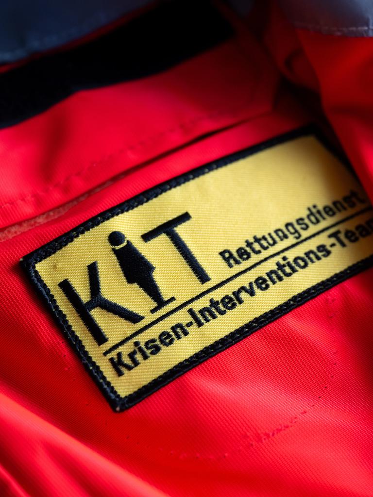 Das Logo vom Münchner Kriseninterventionsteam (KIT, l) und vom Arbeiter-Samariter-Bund (ASB) sind auf einer Uniform zu sehen. 