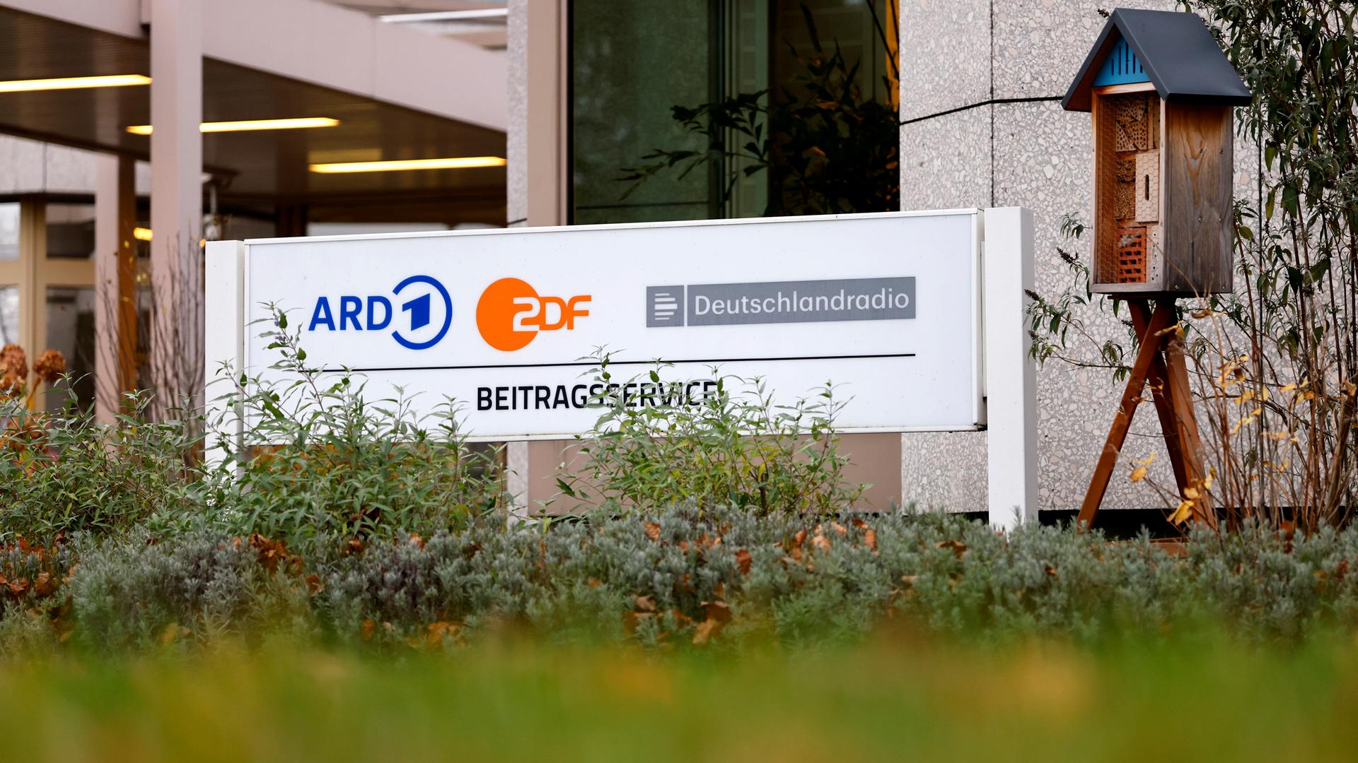 Auf einem Schild sind die Logos von ARD, ZDF und Deutschlandradio zu sehen.