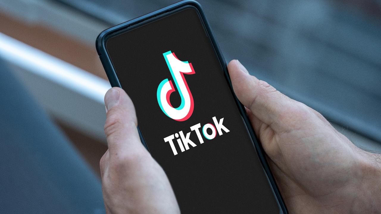Mann hält Smartphone in der Hand mit dem TikTok Logo auf dem Bildschirm. 