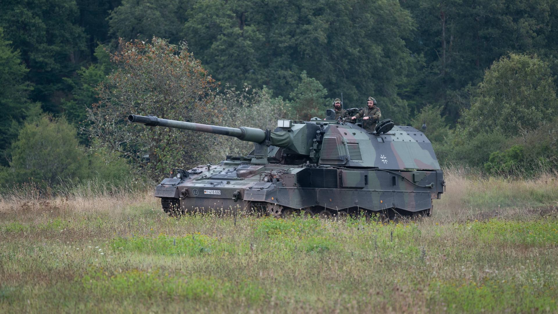 Ein Panzer der Bundeswehr fährt durch ein Gelände.