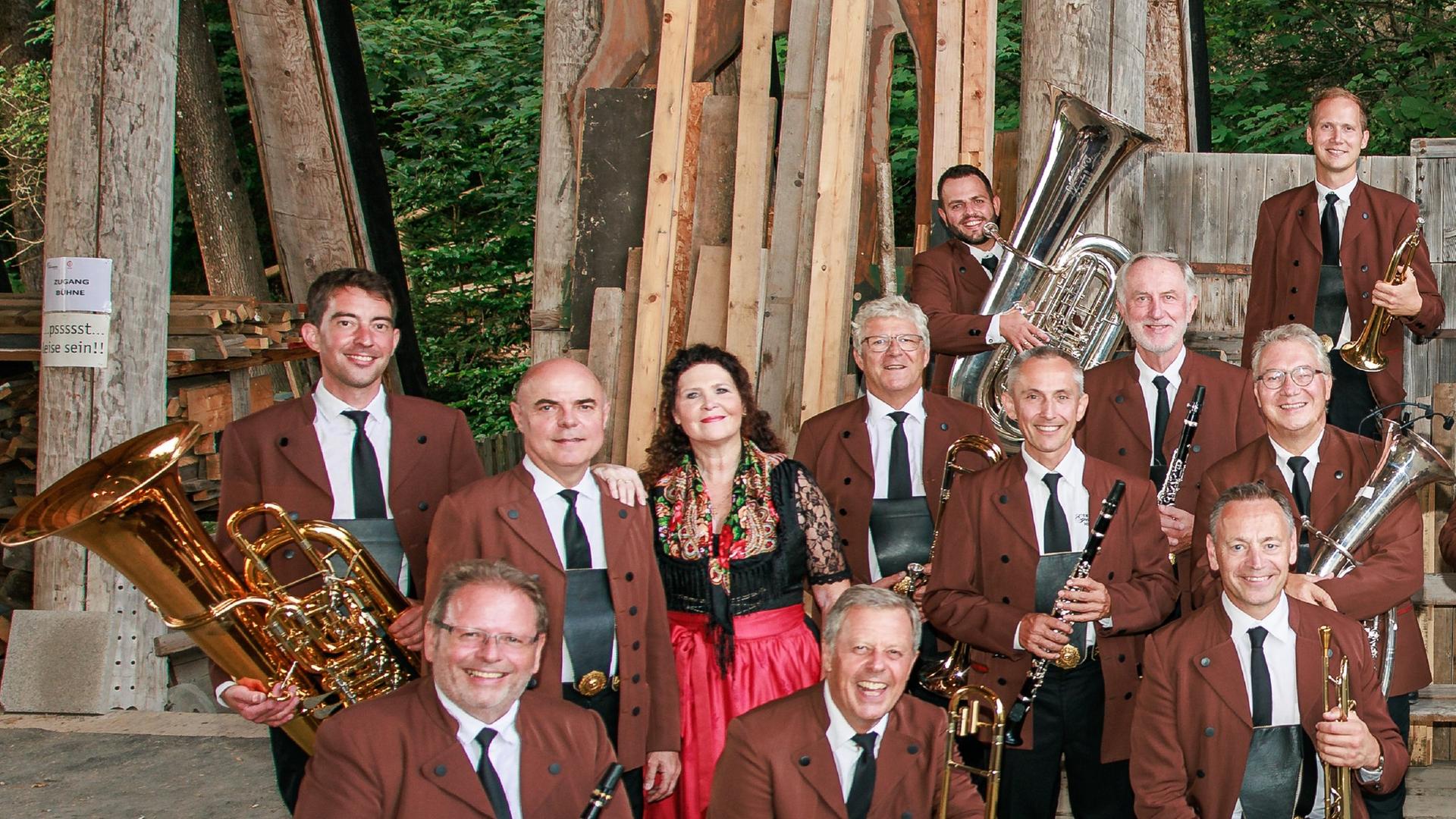 Ein Teil der Musiker sitzt und steht lachend vor der Kamera mit ihren Instrumenten in den Händen. Ein Teil der Musiker sitzt und steht lachend vor der Kamera mit ihren Instrumenten in den Händen.