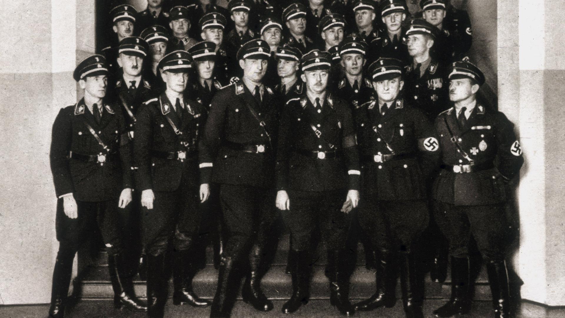 Das Schwarz-Weiß-Foto zeigt Mitglieder der SS mit Heinrich Himmler (mit Brille) auf einer Treppe Das Schwarz-Weiß-Foto zeigt Mitglieder der SS mit Heinrich Himmler (mit Brille) auf einer Treppe