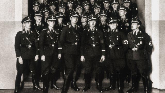 Das Schwarz-Weiß-Foto zeigt Mitglieder der SS mit Heinrich Himmler (mit Brille) auf einer Treppe Das Schwarz-Weiß-Foto zeigt Mitglieder der SS mit Heinrich Himmler (mit Brille) auf einer Treppe