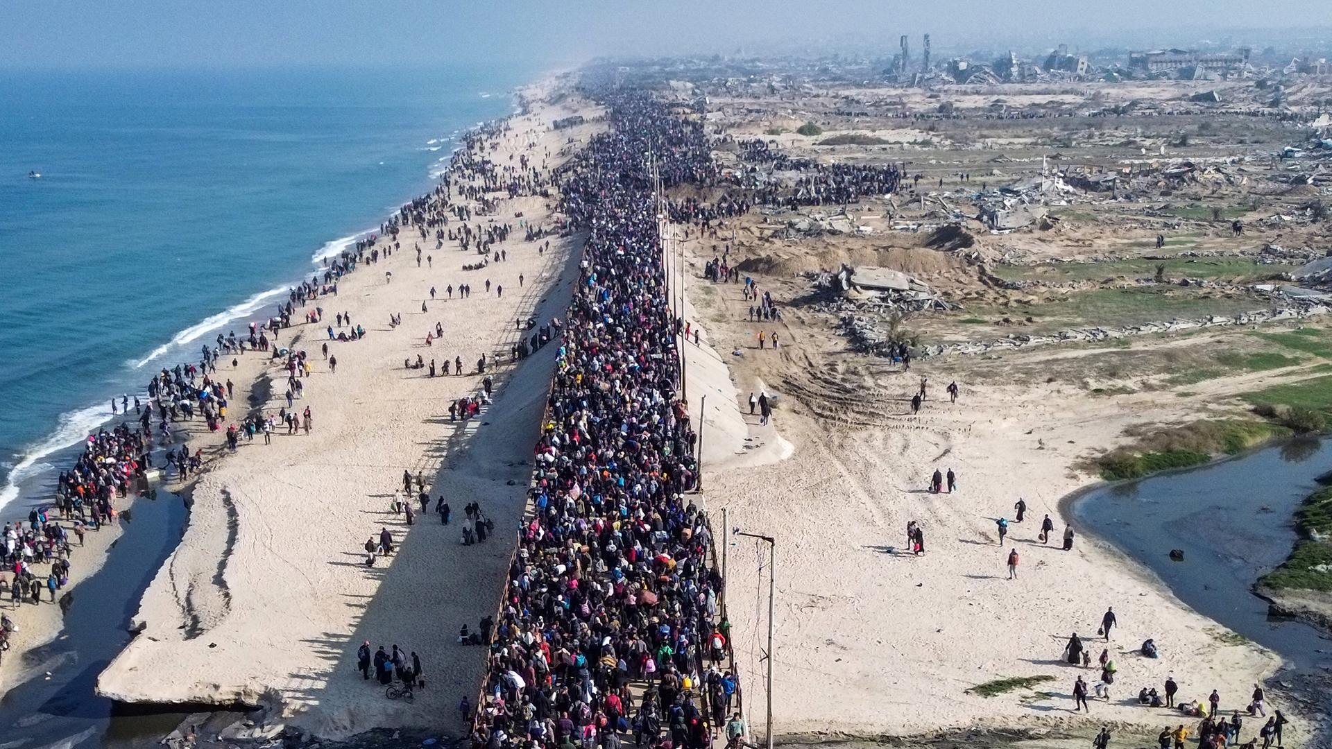 Eine Luft-Aufnahme zeigt tausende Palästinenser, die an der Küste vom Gaza-Streifen in Richtung Norden laufen. 