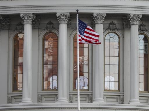 Blick auf das Capitol in Washington mit der US-amerikanischen Flagge.
