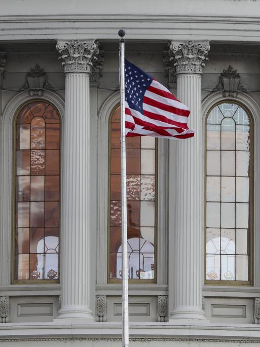 Blick auf das Capitol in Washington mit der US-amerikanischen Flagge.