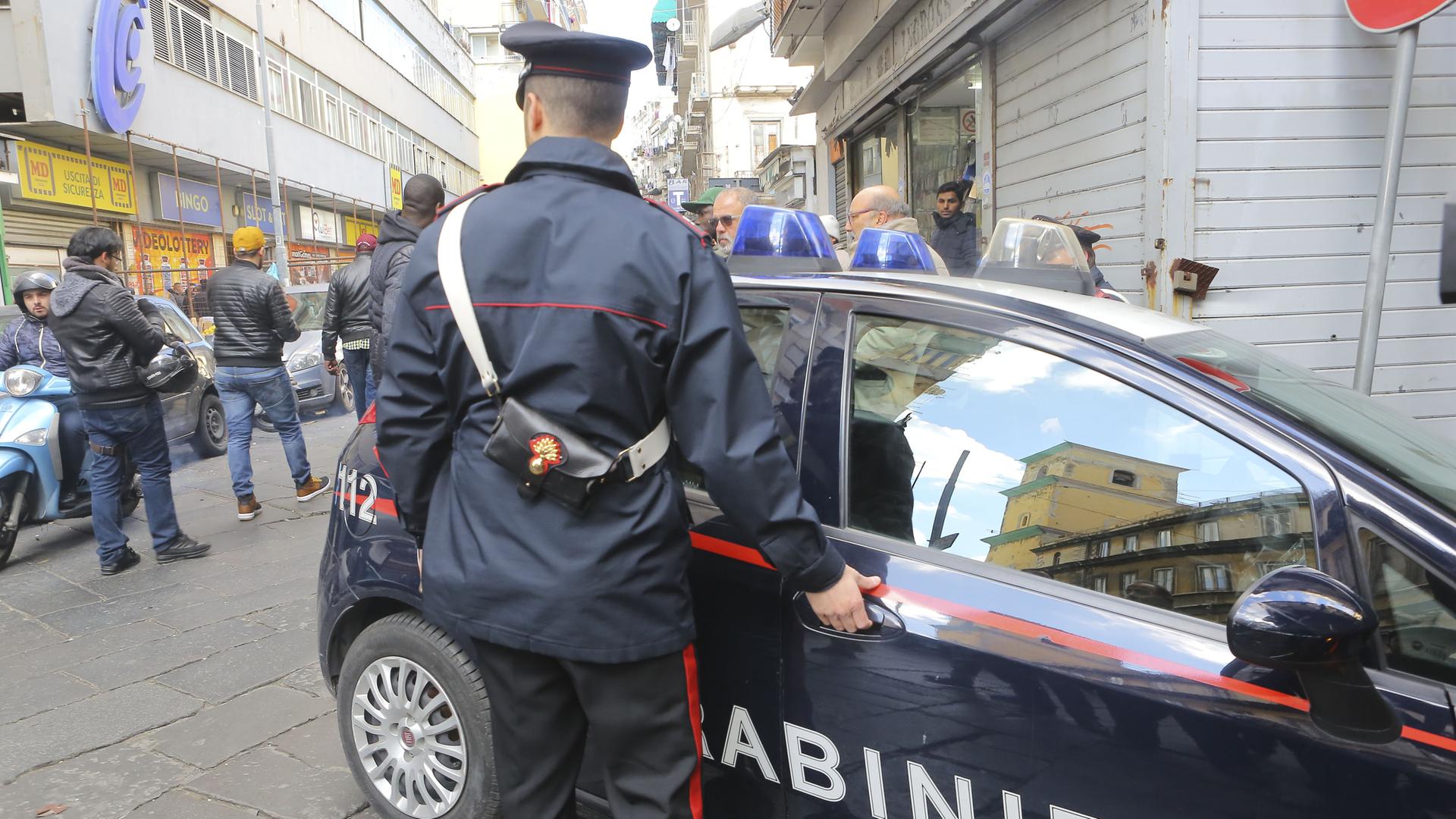 Carabinieri sind mit einem Polizeiwagen an einem Tatort in Neapel. 