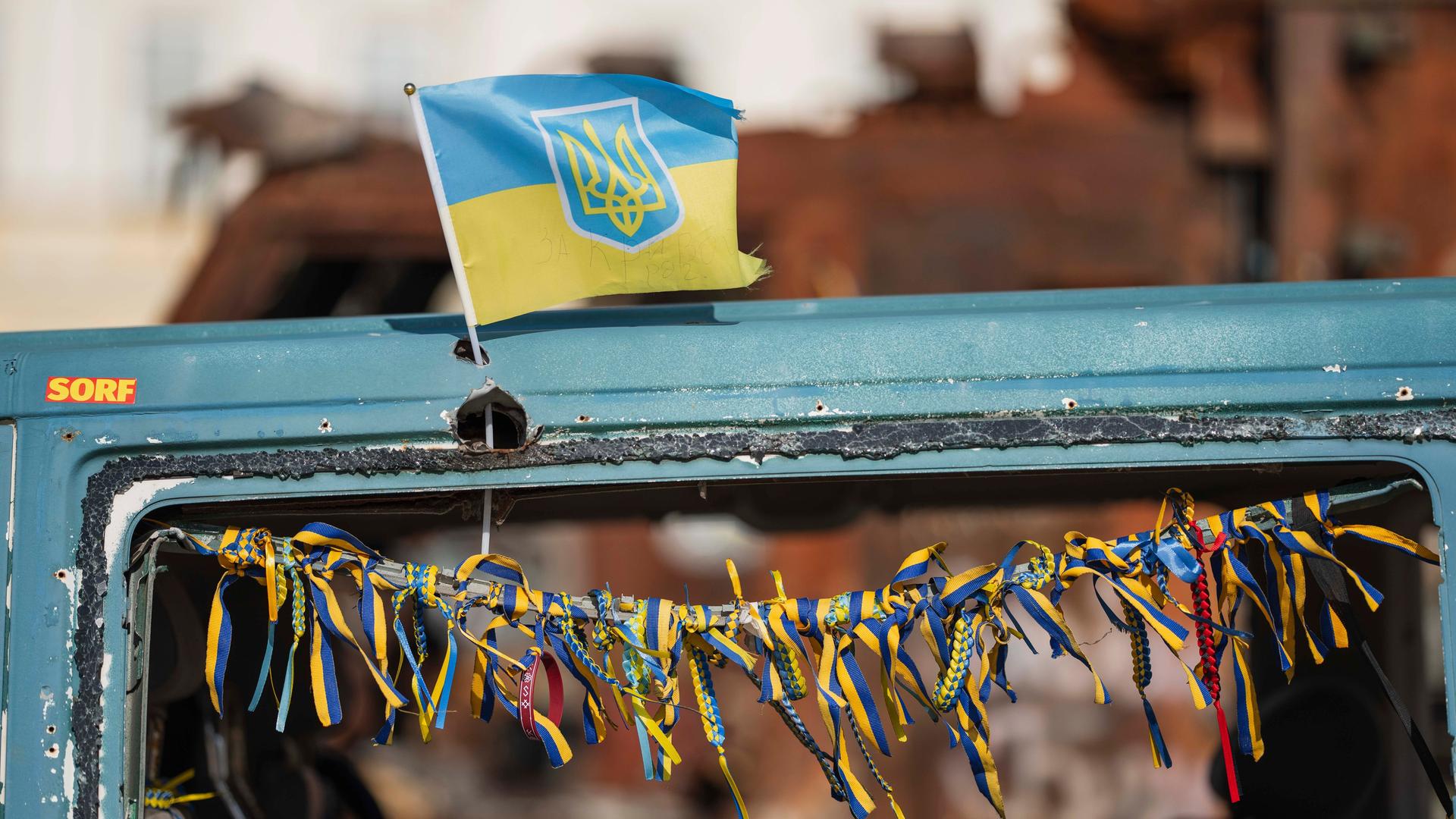 Eine kleine ukrainische Flagge ist an einem zerstörten russischen Fahrzeug befestigt, das in Kiew im Stadtzentrum ausgestellt steht. 