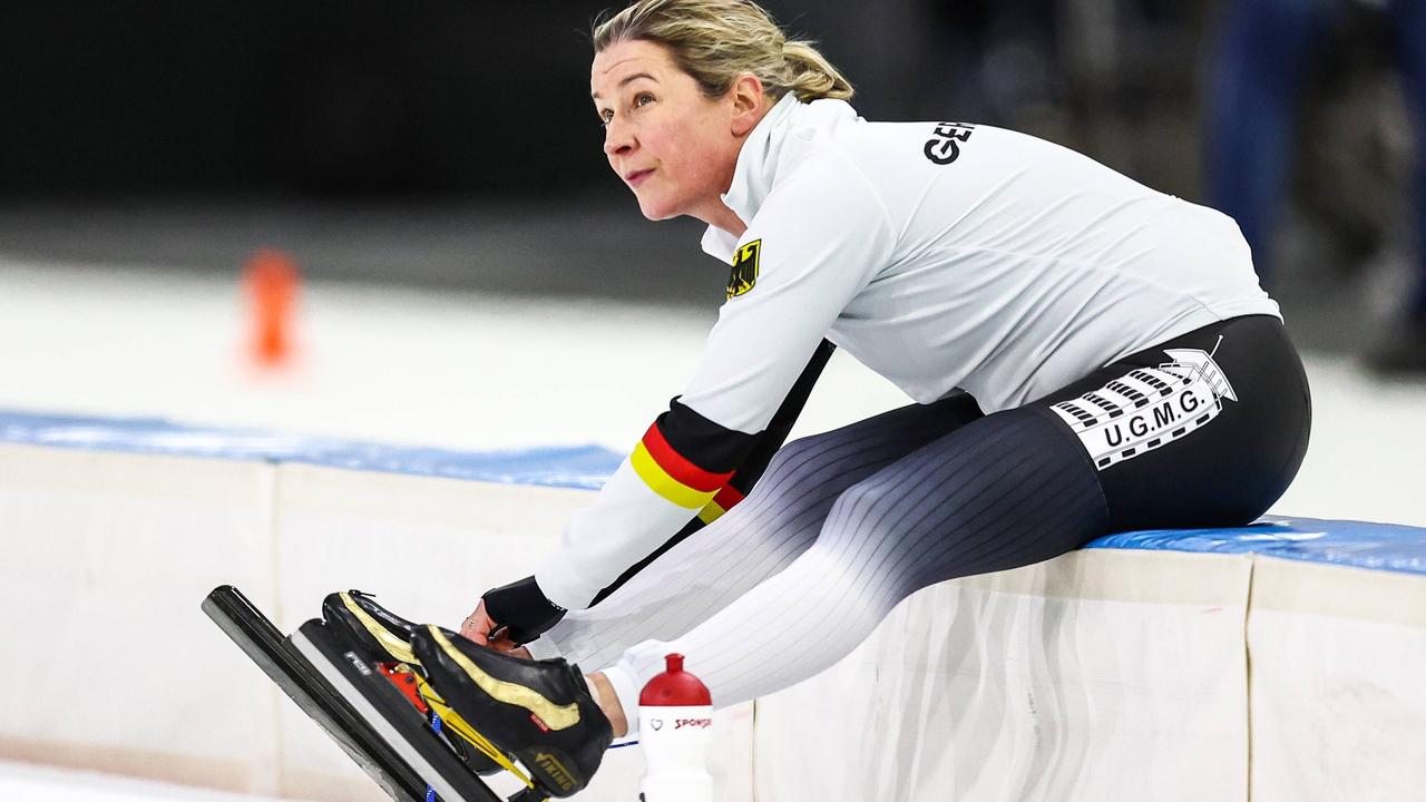 Claudia Pechstein bindet sitzend ihre Schlittschuhe bei der Eisschnelllauf-WM in Herenveen 2023.