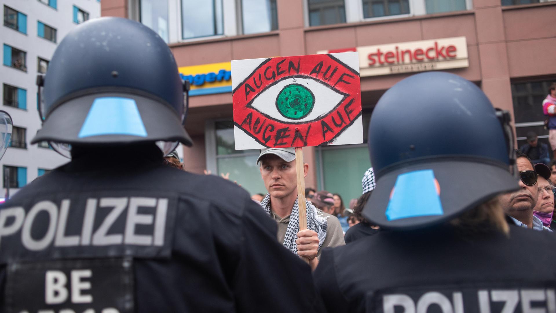 Zwei Polizisten von hinten bei einer Demonstration gegen den Gaza-Krieg in Berlin.  