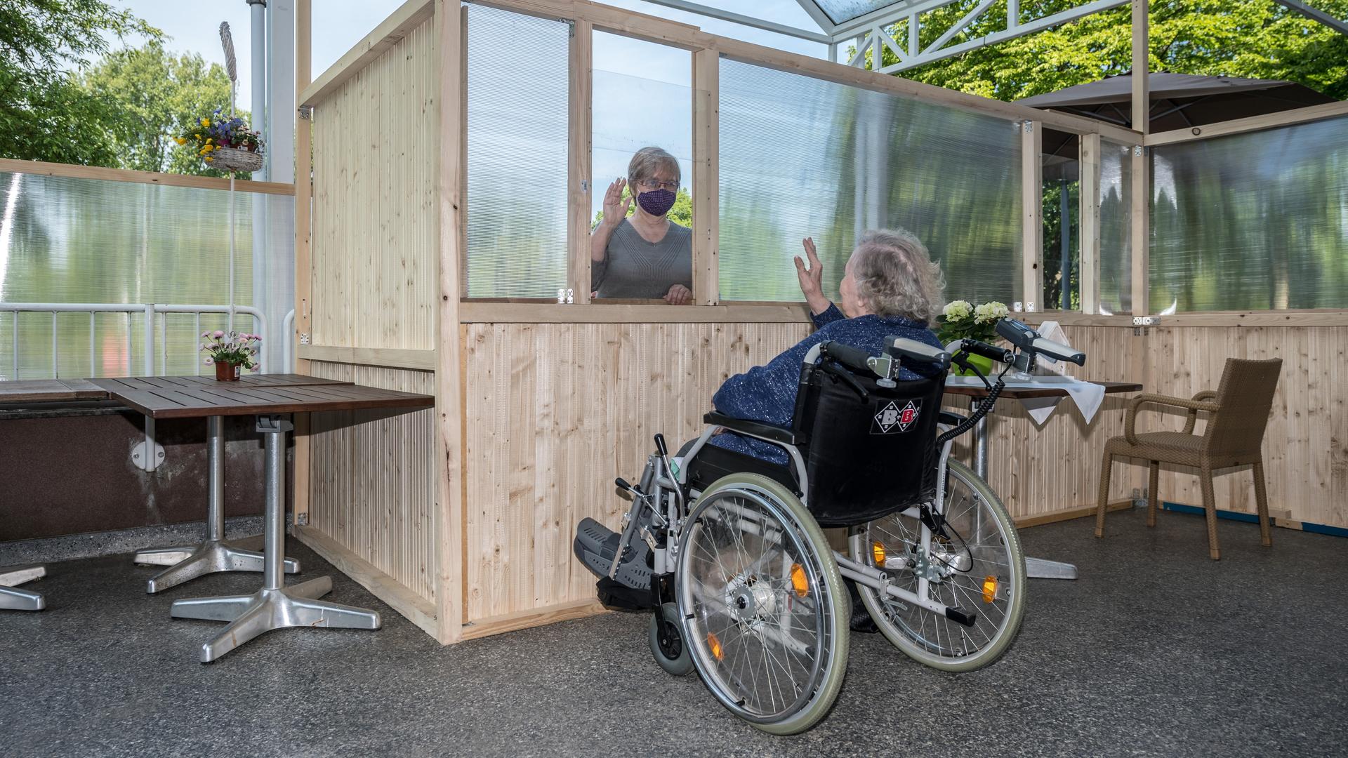 Barbara Fabian besucht am Freitag, 08.05.2020, ihre 87-jährige Mutter Irene Termin im Franziskushaus in Mülheim an der Ruhr. Dabei sind die beiden auf der Terrasse des Hauses durch einen Holzzaun und Plexiglasscheiben getrennt.