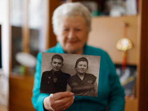 Die Holocaust-Überlebende Assia Gorban zeigt ein Bild von ihr und ihrem Bruder Yitzhak während eines Interviews mit The Associated Press in Berlin, Deutschland, Montag, 3. April 2023. 