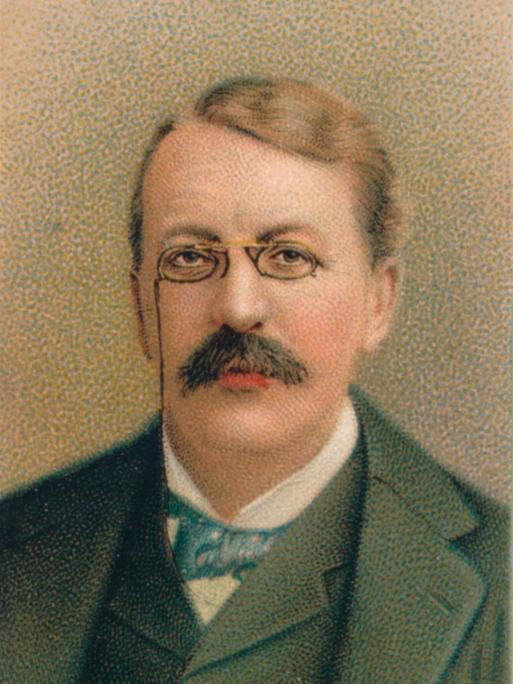 Nochkoloriertes Porträt von  Sir Charles Villiers Stanford, das wohl um 1911 entstand und ihn mit Brille und vornehmen Anzug zeigt.