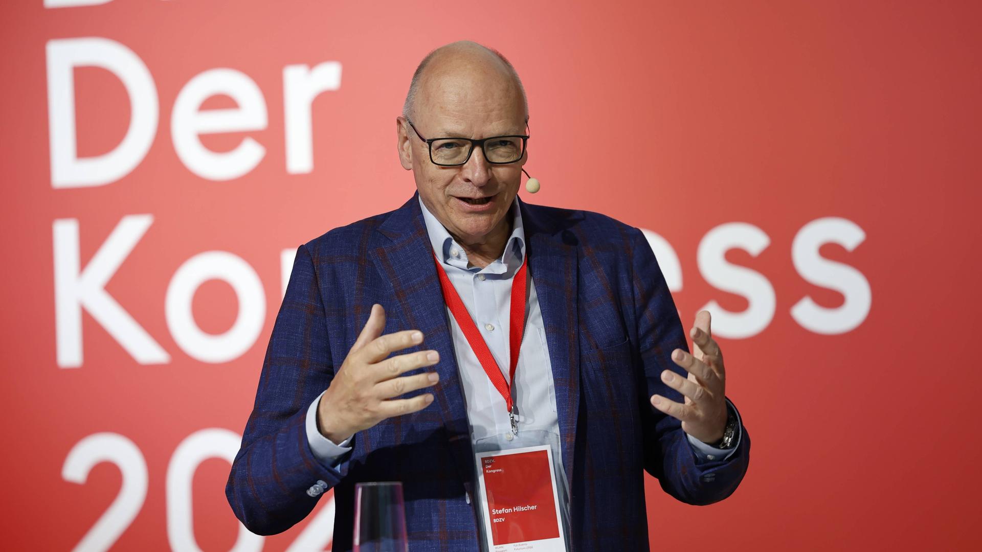 Stefan Hilscher steht an einem Rednerpult, hinter ihm sieht man einen roten Hintergrund Stefan Hilscher steht an einem Rednerpult, hinter ihm sieht man einen roten Hintergrund