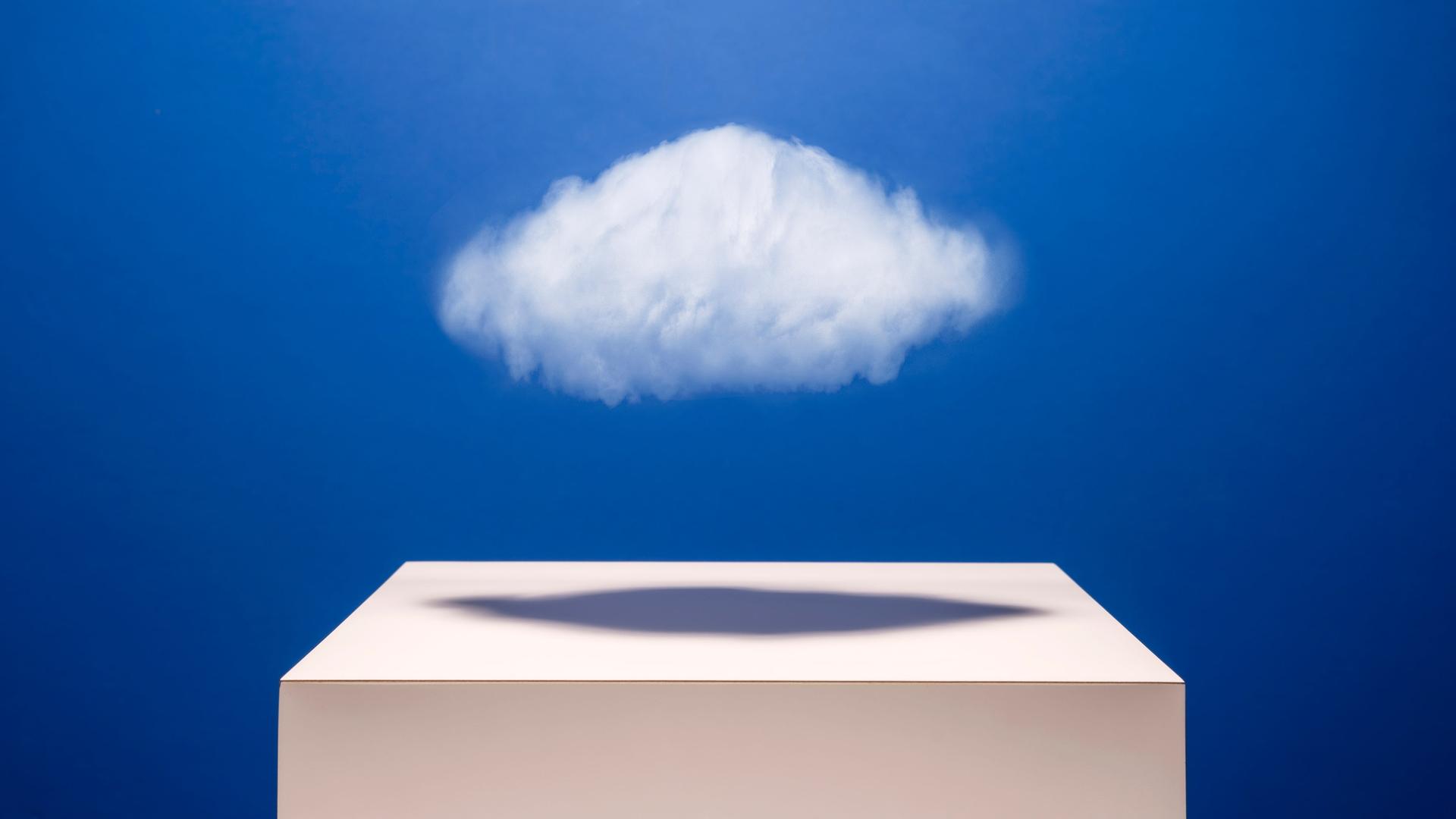 Eine kleine weiße Wolke schwebt über einem weißen Podest.