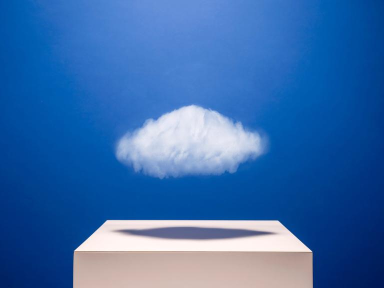 Eine kleine weiße Wolke schwebt über einem weißen Podest.