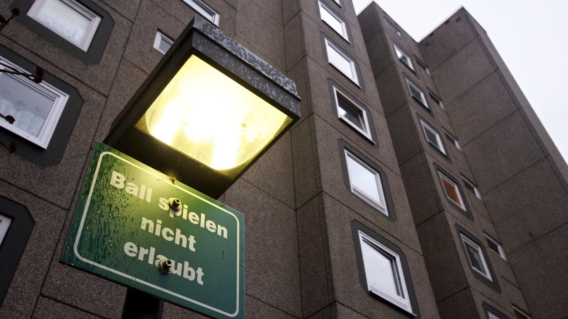 Ein Schild mit der Aufschrift "Ball spielen nicht erlaubt" vor einem Hochhaus.